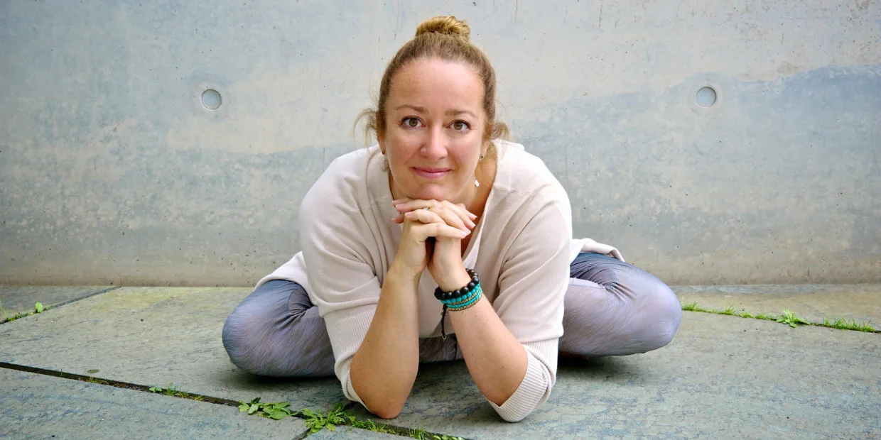 Eileen Seibt lächelnd in einer sitzenden Yoga-Haltung